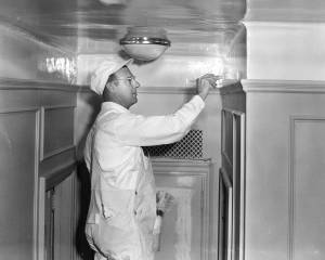 A white-clad professional painter demonstrates a new odorless Du Pont product--with a brush. Photograph. E.I. du Pont Nemours & Company. 1950s. Courtesy of the Hagley Museum and Library, digital collections, 1972341_2901.tif.