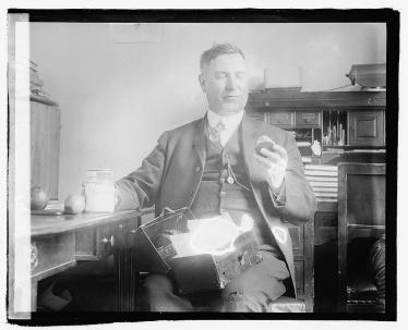 Glass negative picturing Percy A. Quin, U.S. Representative (D-Mississippi), 26 March 1920. A caption outlines Quin's plan to counter high costs of living: "Wear your old cloths, have them patched and darned, wear a celluloid collar, carry your lunch etc. etc." (Courtesy of the Library of Congress, Prints & Photographs Division, LC-F8- 7276.)
